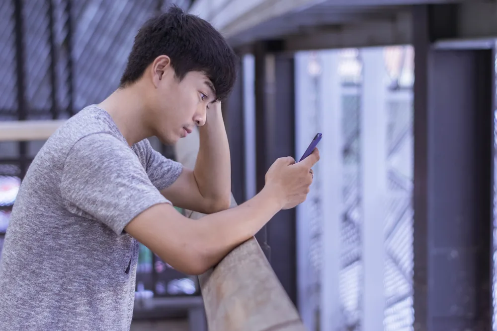 スマホを前に悩む男性